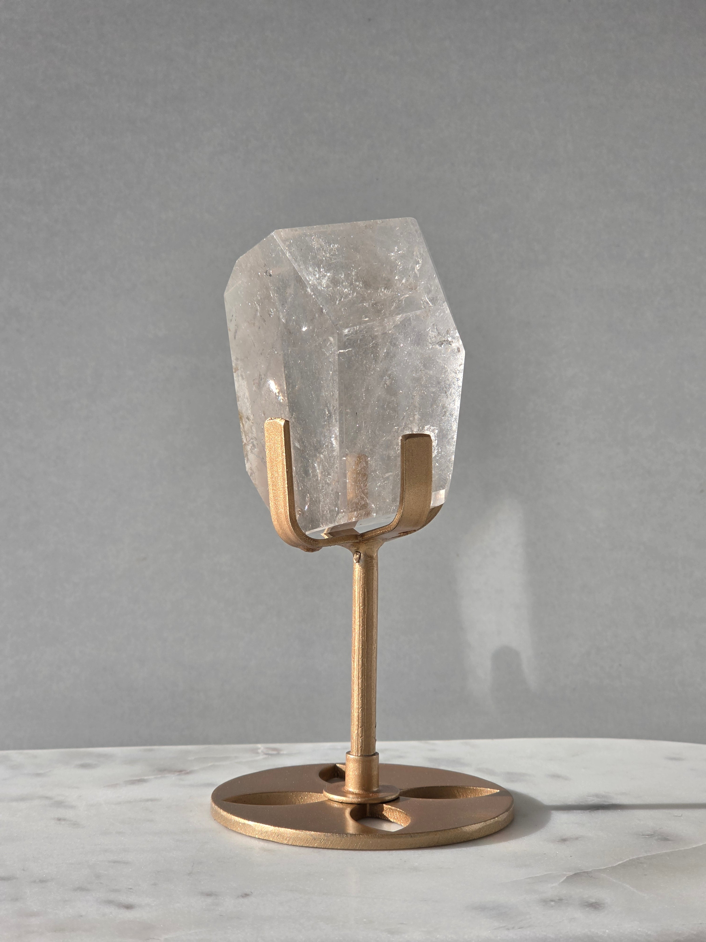 Clear Quartz freeform crystal with subtle smoky-grey translucence, natural internal inclusions and luminous clarity, displayed on an elegant gold-finished stand.