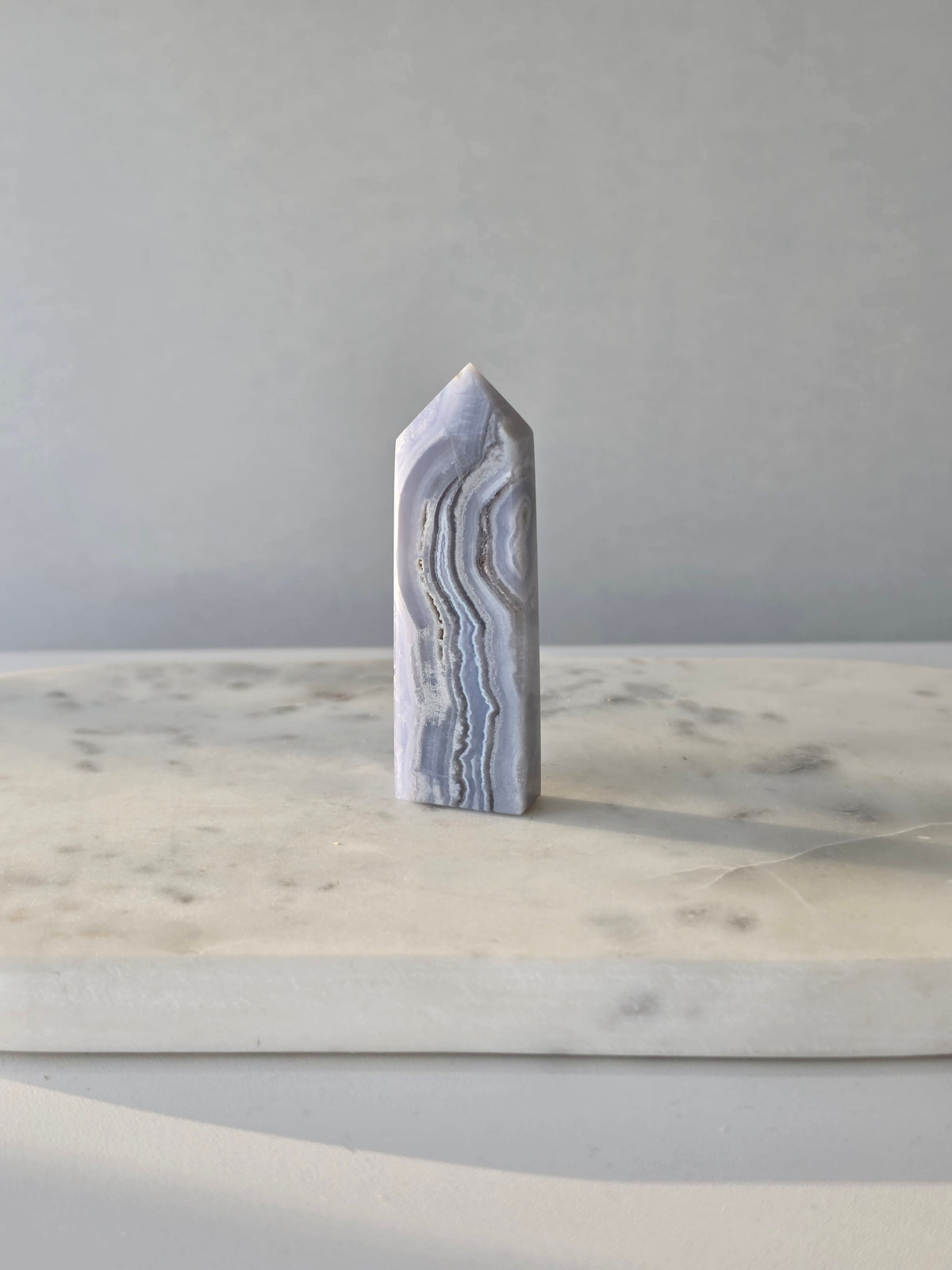 Natural Blue Lace Agate crystal point with soft blue and white banding, polished finish and unique natural formations
