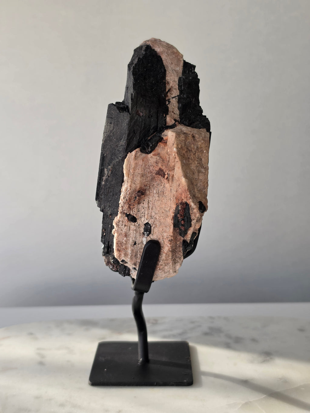 Black Tourmaline on Feldspar matrix from Brazil featuring naturally formed black crystals, contrasting pale matrix, black display stand, 910g, 19.5 × 6.5cm.