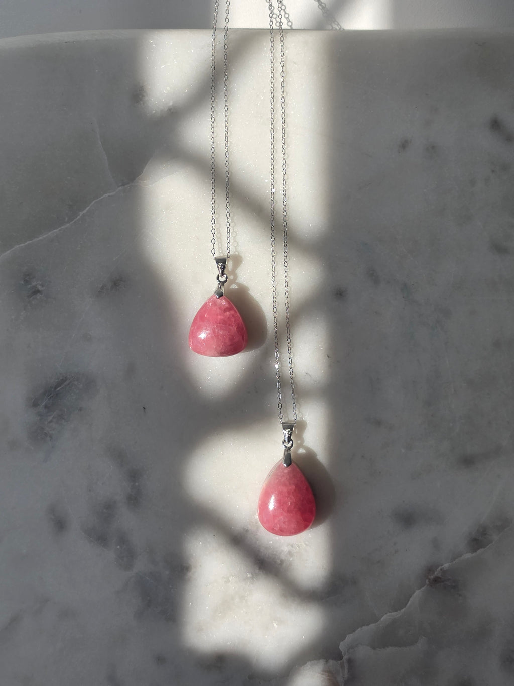 Natural Rhodochrosite teardrop pendant in 925 sterling silver with matching silver chain, featuring vibrant pink tones and unique natural patterns