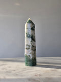 Natural Moss Agate crystal point with forest green moss-like inclusions on a milky white translucent base