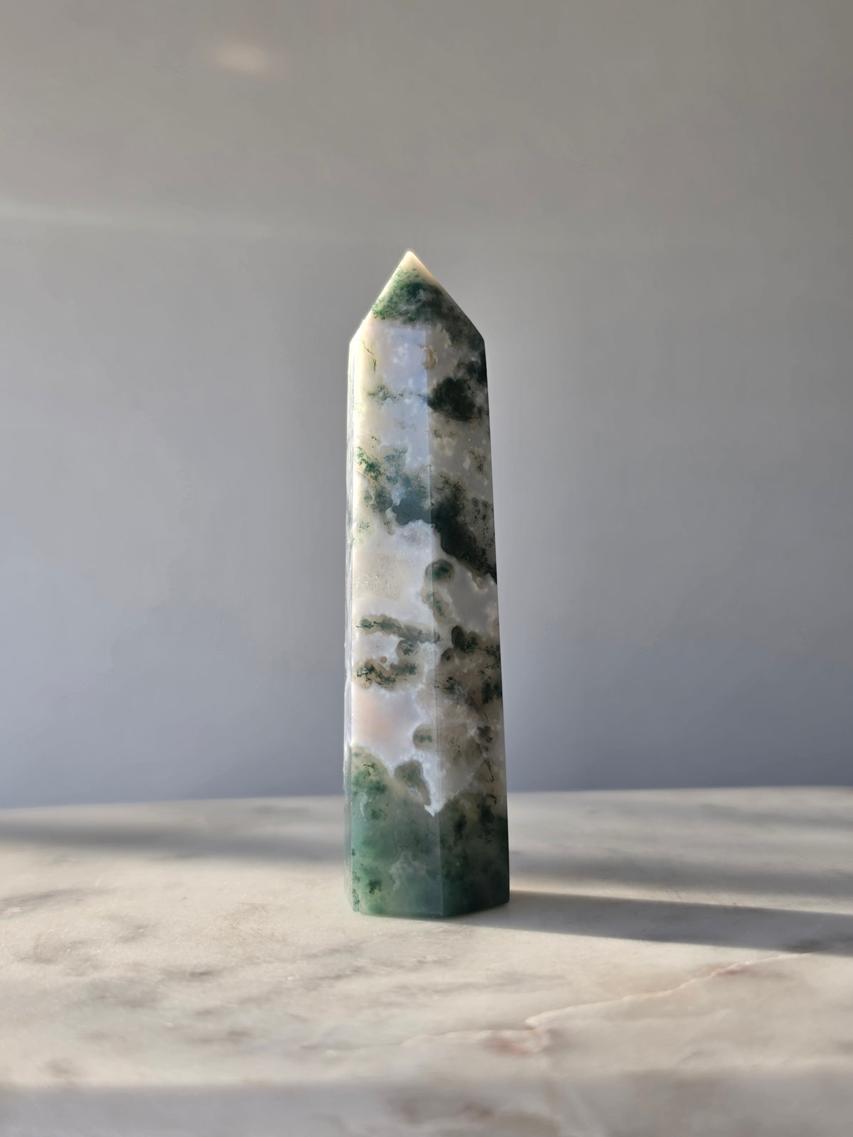 Natural Moss Agate crystal point with forest green moss-like inclusions on a milky white translucent base