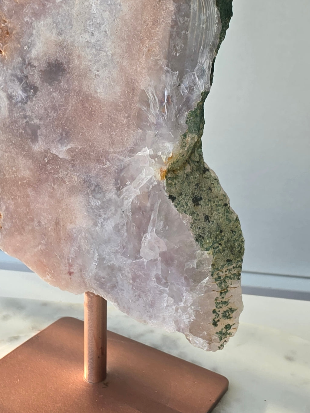 Large Brazilian Pink Amethyst slice on display stand with translucent Quartz, sparkling crystalline texture, earthy brown Jasper features and deep green natural matrix
