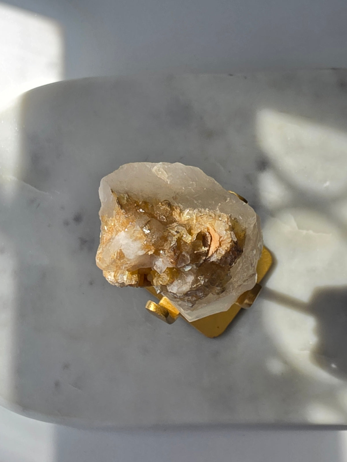 Brazilian Golden Mica on Matrix mineral specimen featuring shimmering golden mica crystals within a pale translucent matrix, displayed on a gold-toned stand.
