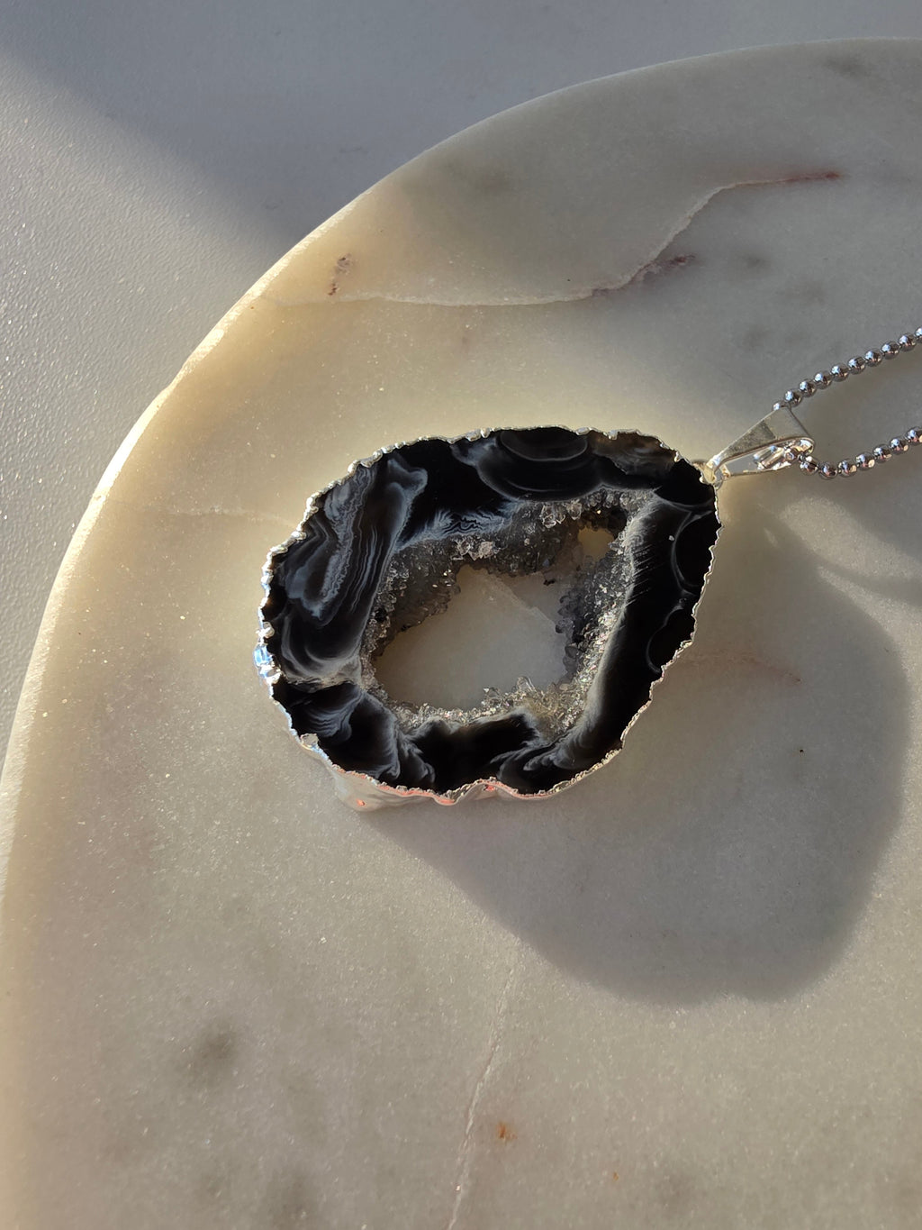"Brazilian Agate Geode Slice Pendant in natural [brown/black/grey] tones on a silver plated chain with sparkling druzy crystal formations"