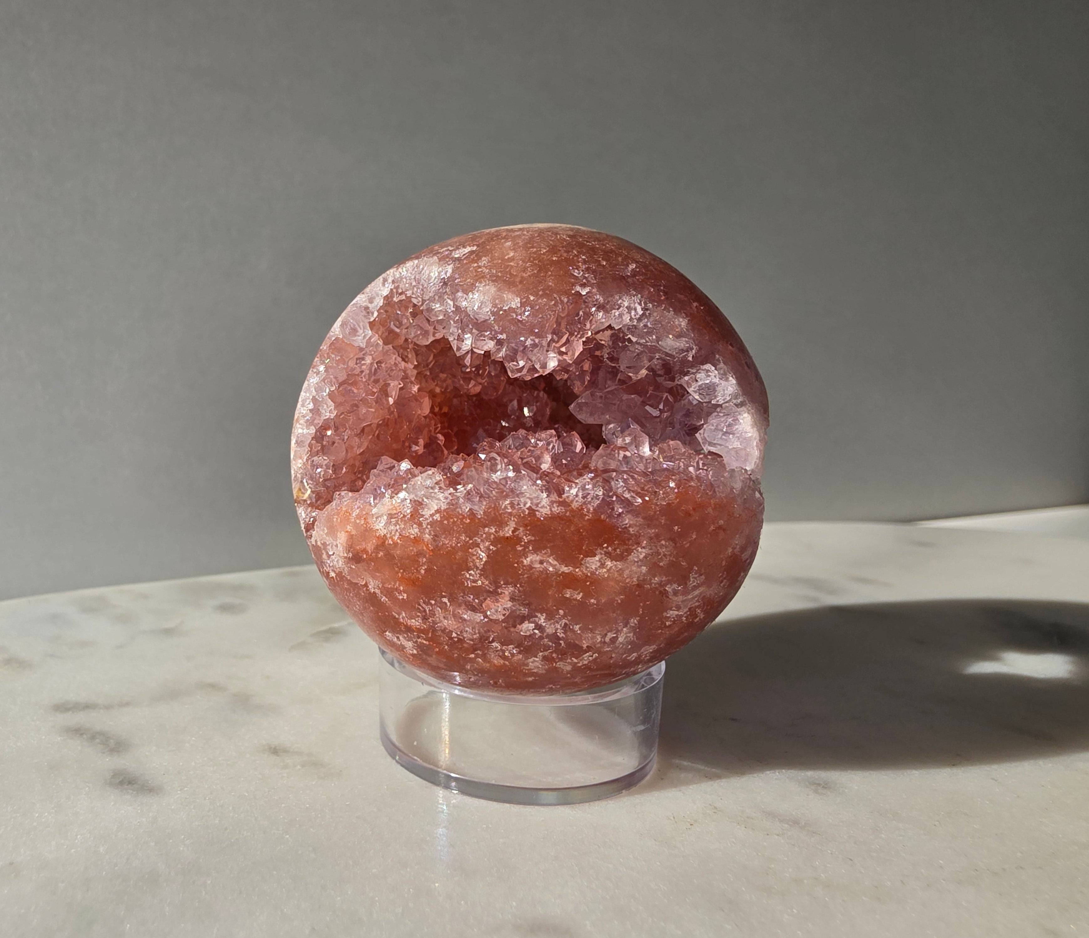 Brazilian Pink Amethyst sphere in rich blush and red-pink tones with sparkling druzy crystal formations and a natural crystalline centre, Stone & Bloom