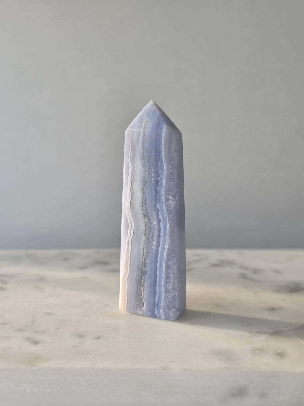 Natural Blue Lace Agate crystal point with soft blue and white banding, polished finish and unique natural formations