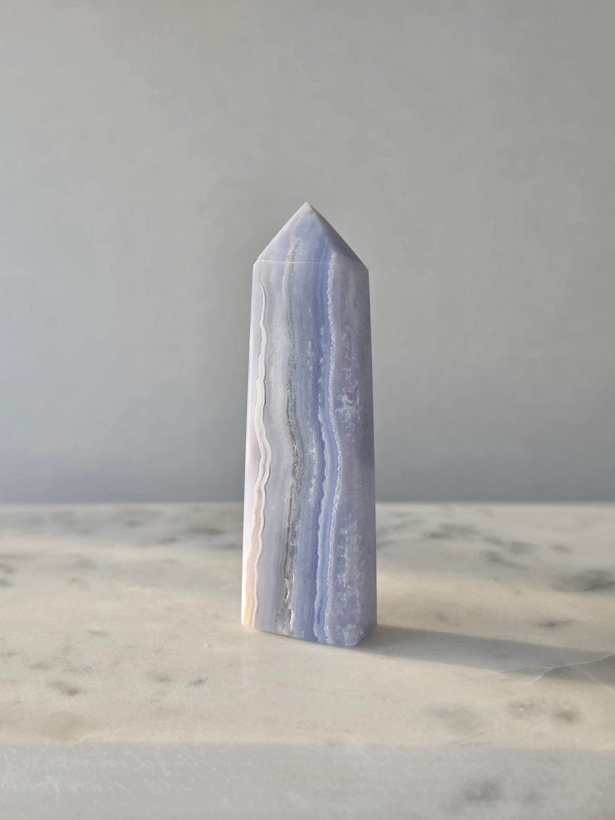 Natural Blue Lace Agate crystal point with soft blue and white banding, polished finish and unique natural formations