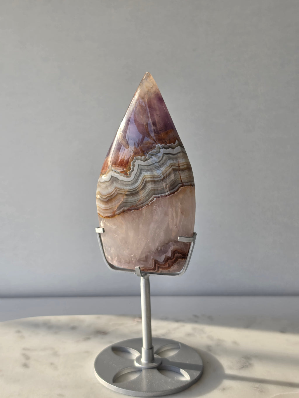 Amethyst Lace Agate flame on a silver stand featuring soft lavender, lilac and creamy white natural banding and intricate lace-like patterns, luxury crystal décor.