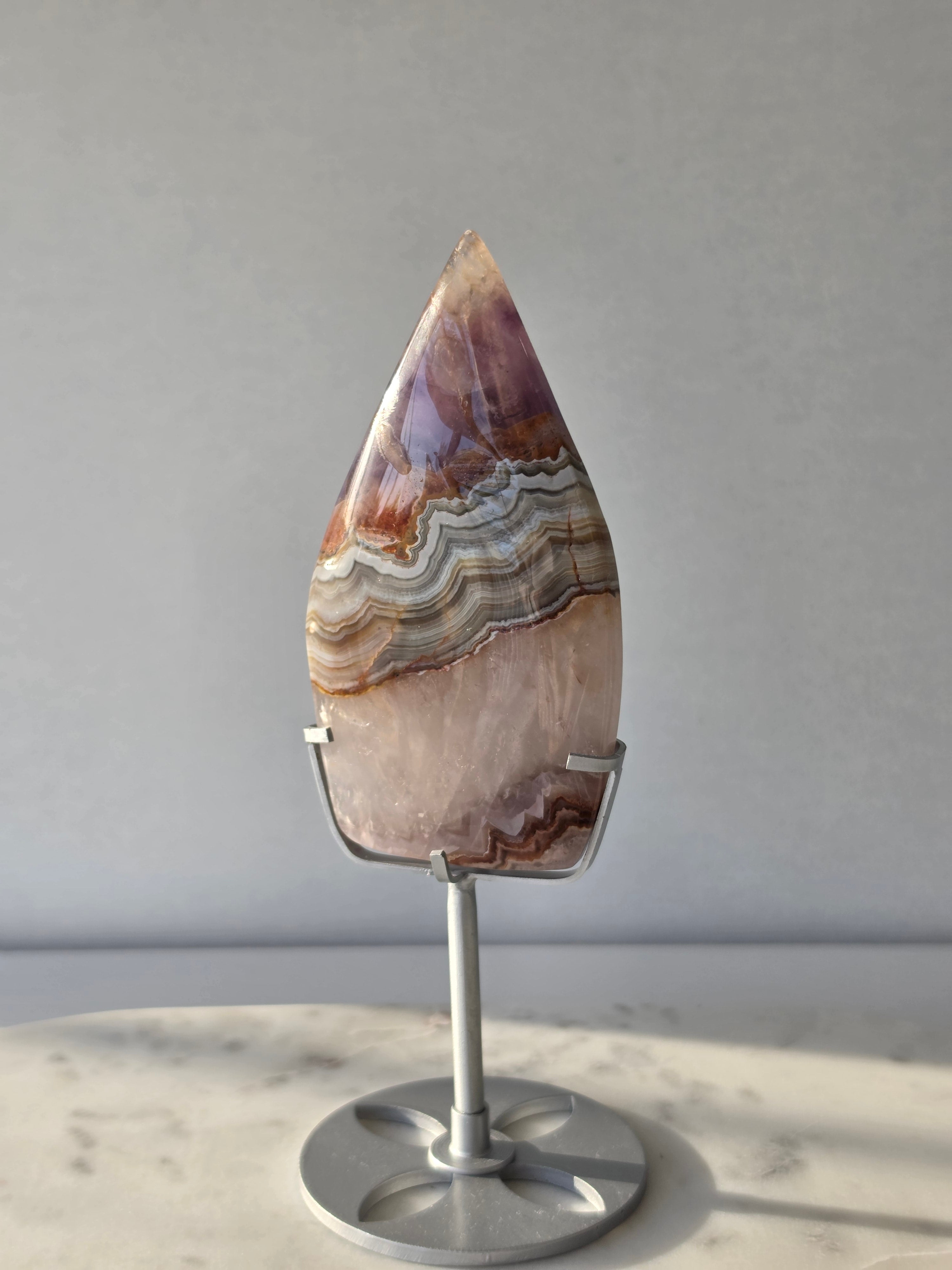 Amethyst Lace Agate flame on a silver stand featuring soft lavender, lilac and creamy white natural banding and intricate lace-like patterns, luxury crystal décor.