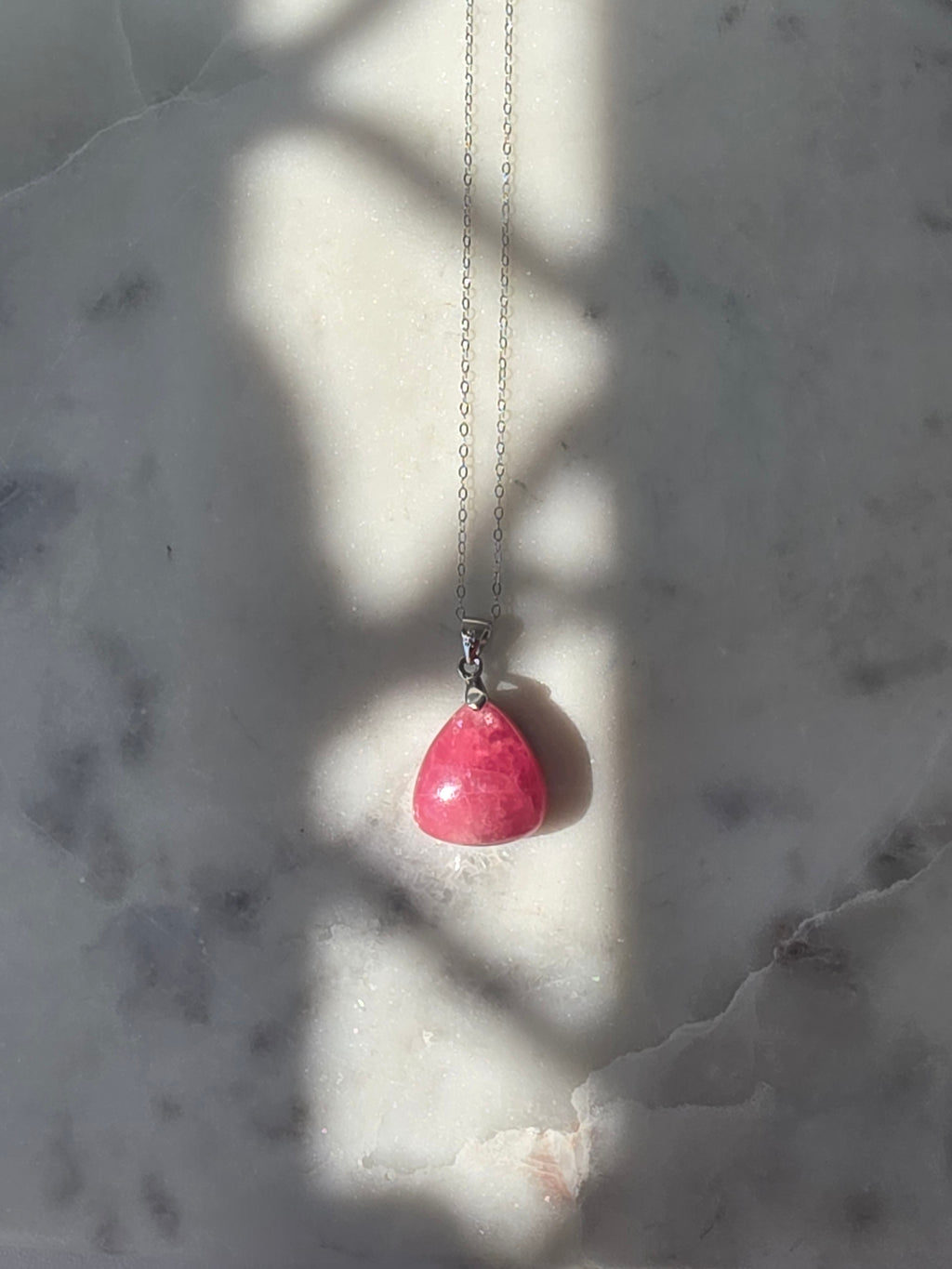 Natural Rhodochrosite teardrop pendant in 925 sterling silver with matching silver chain, featuring vibrant pink tones and unique natural patterns