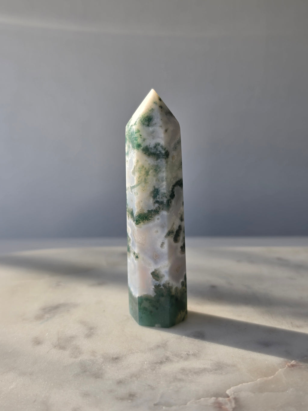 Natural Moss Agate crystal point with forest green moss-like inclusions on a milky white translucent base