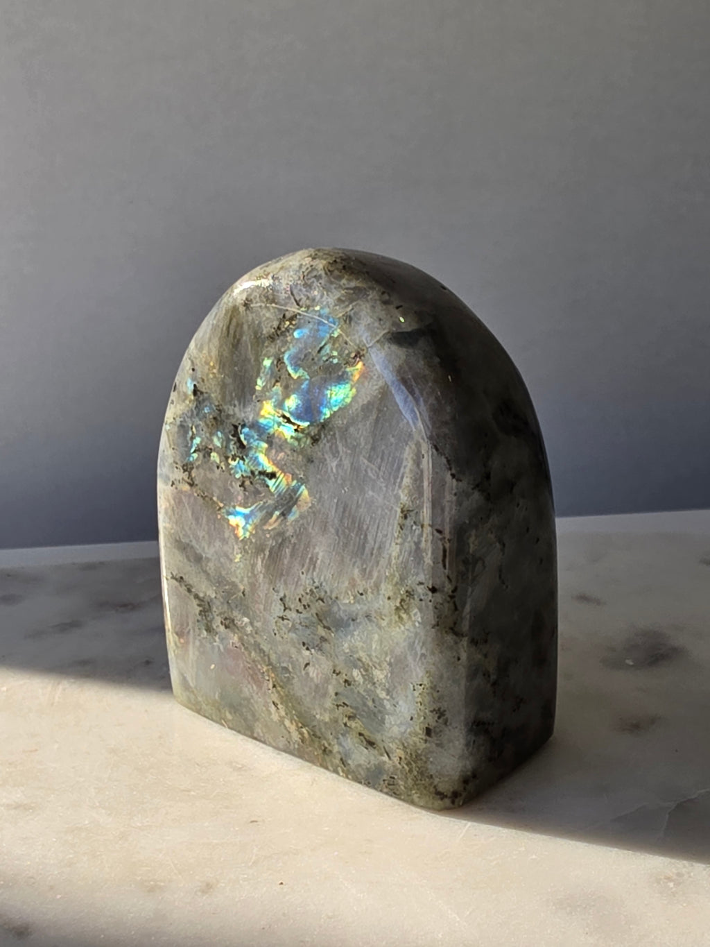 353g polished Labradorite cut base featuring vivid blue, turquoise and golden-green iridescent flashes across a smoky grey and charcoal natural stone.