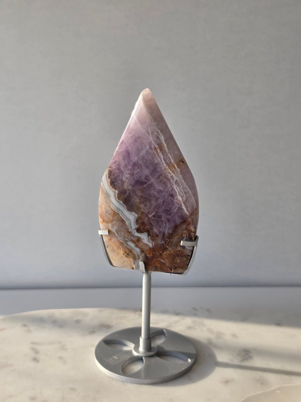 Amethyst Lace Agate flame on a silver stand featuring soft lavender, lilac and creamy white natural banding and intricate lace-like patterns, luxury crystal décor.