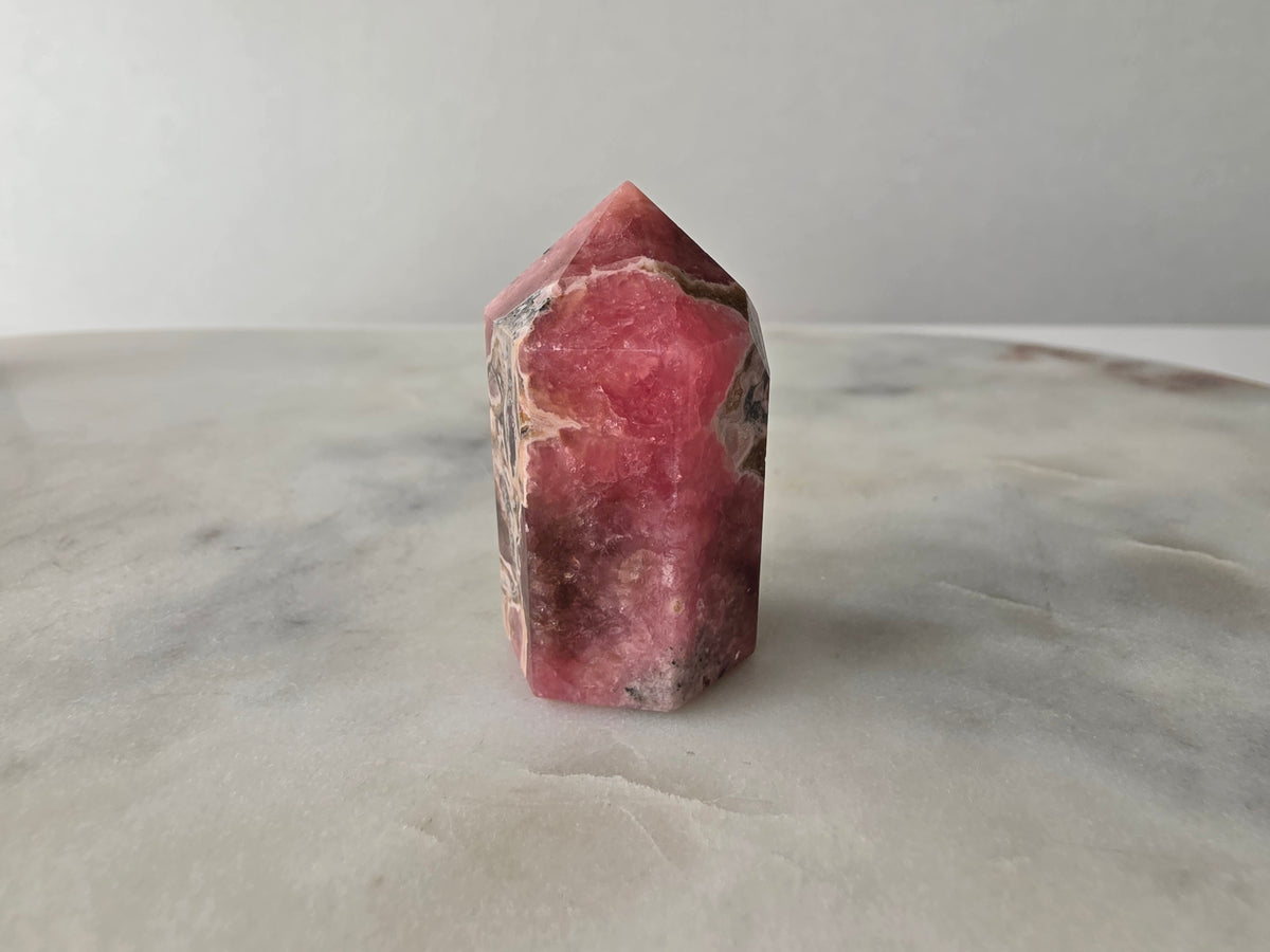 Polished Argentine Rhodochrosite crystal point with deep raspberry pink colour and intricate cream, blush and dark mineral banding, 37g, 4cm.