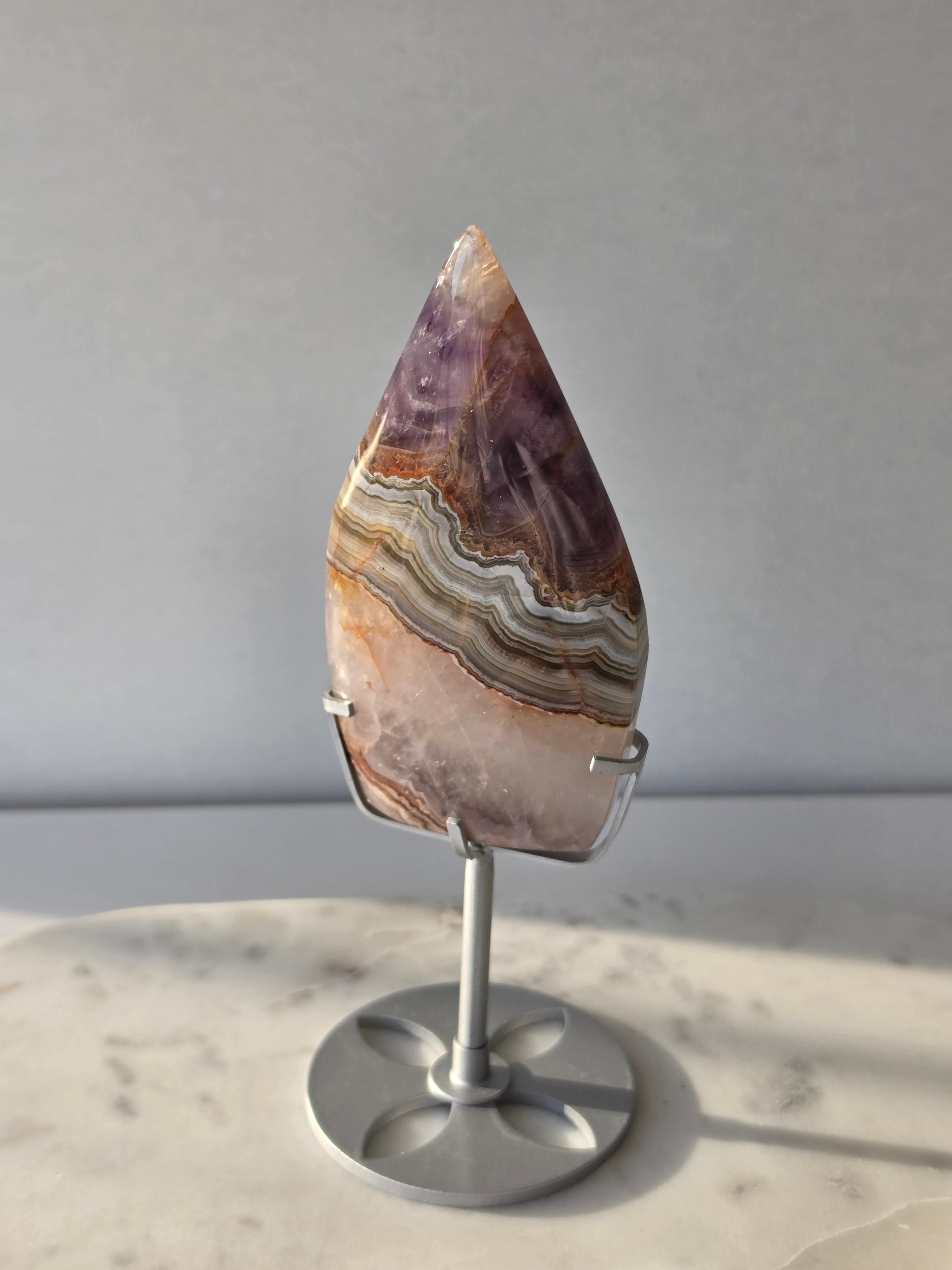 Amethyst Lace Agate flame on a silver stand featuring soft lavender, lilac and creamy white natural banding and intricate lace-like patterns, luxury crystal décor.