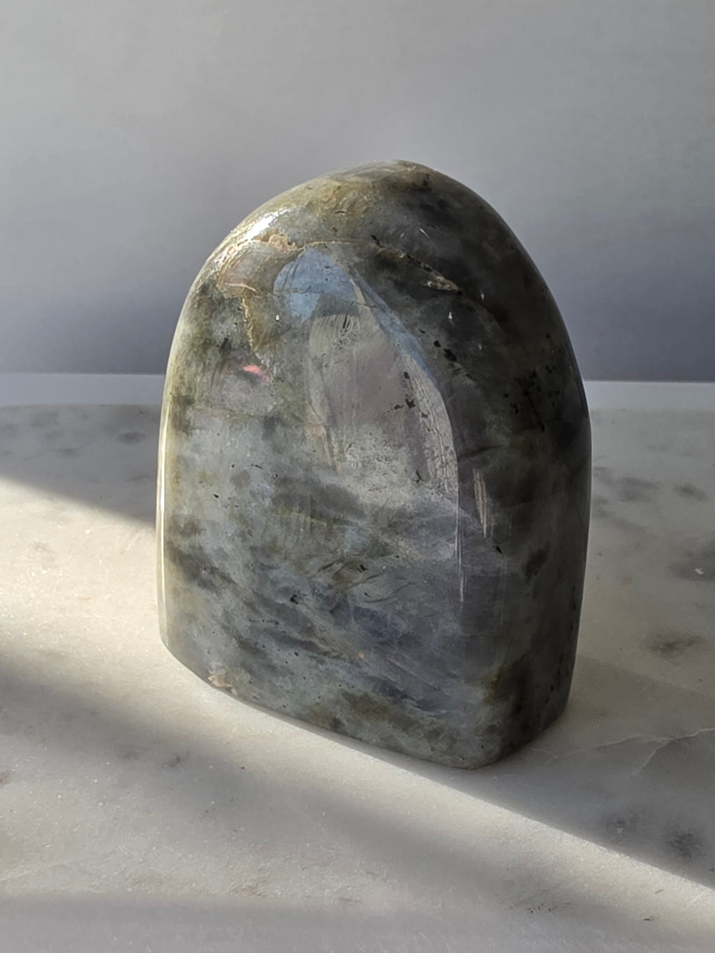 353g polished Labradorite cut base featuring vivid blue, turquoise and golden-green iridescent flashes across a smoky grey and charcoal natural stone.