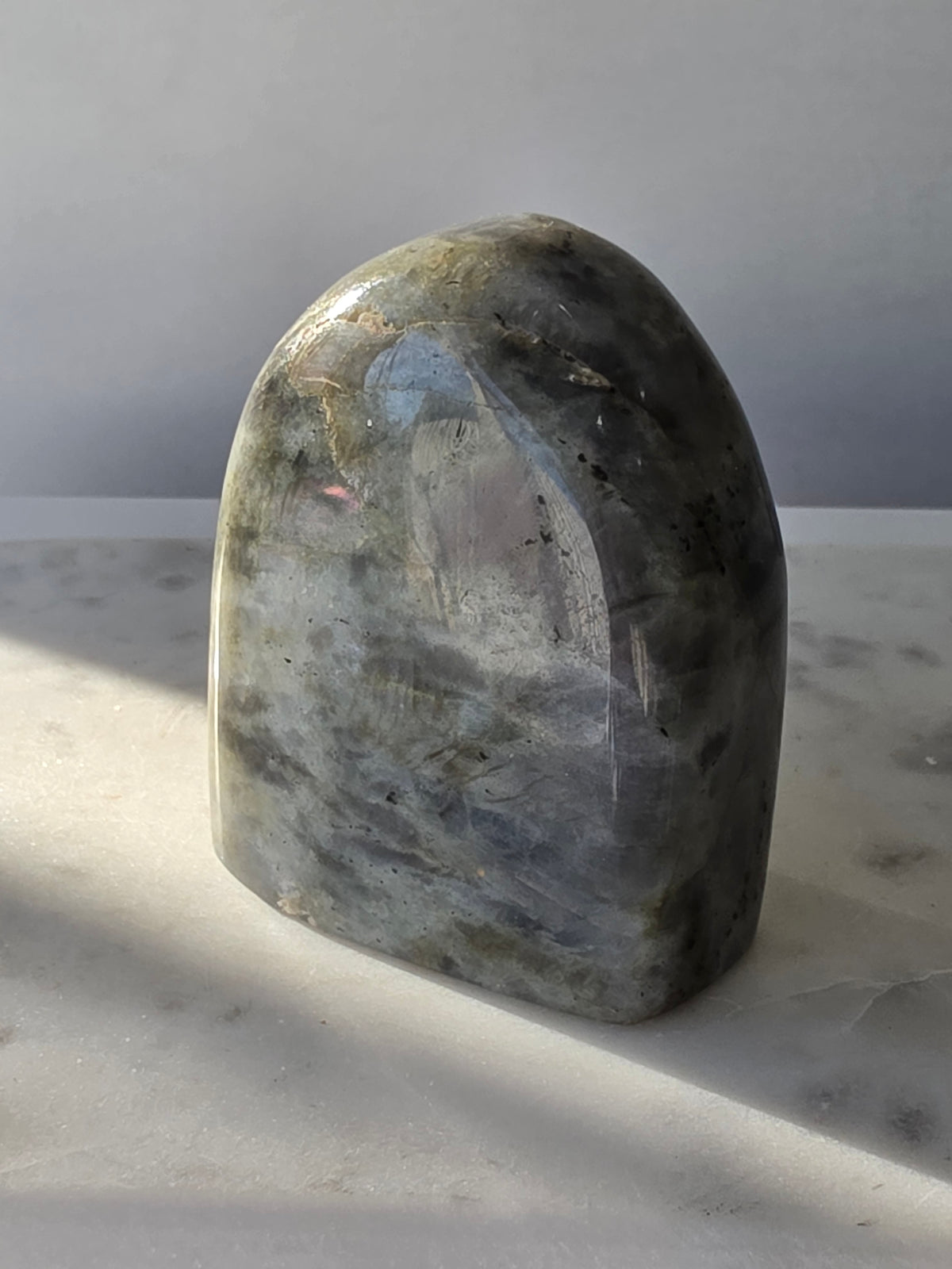 353g polished Labradorite cut base featuring vivid blue, turquoise and golden-green iridescent flashes across a smoky grey and charcoal natural stone.