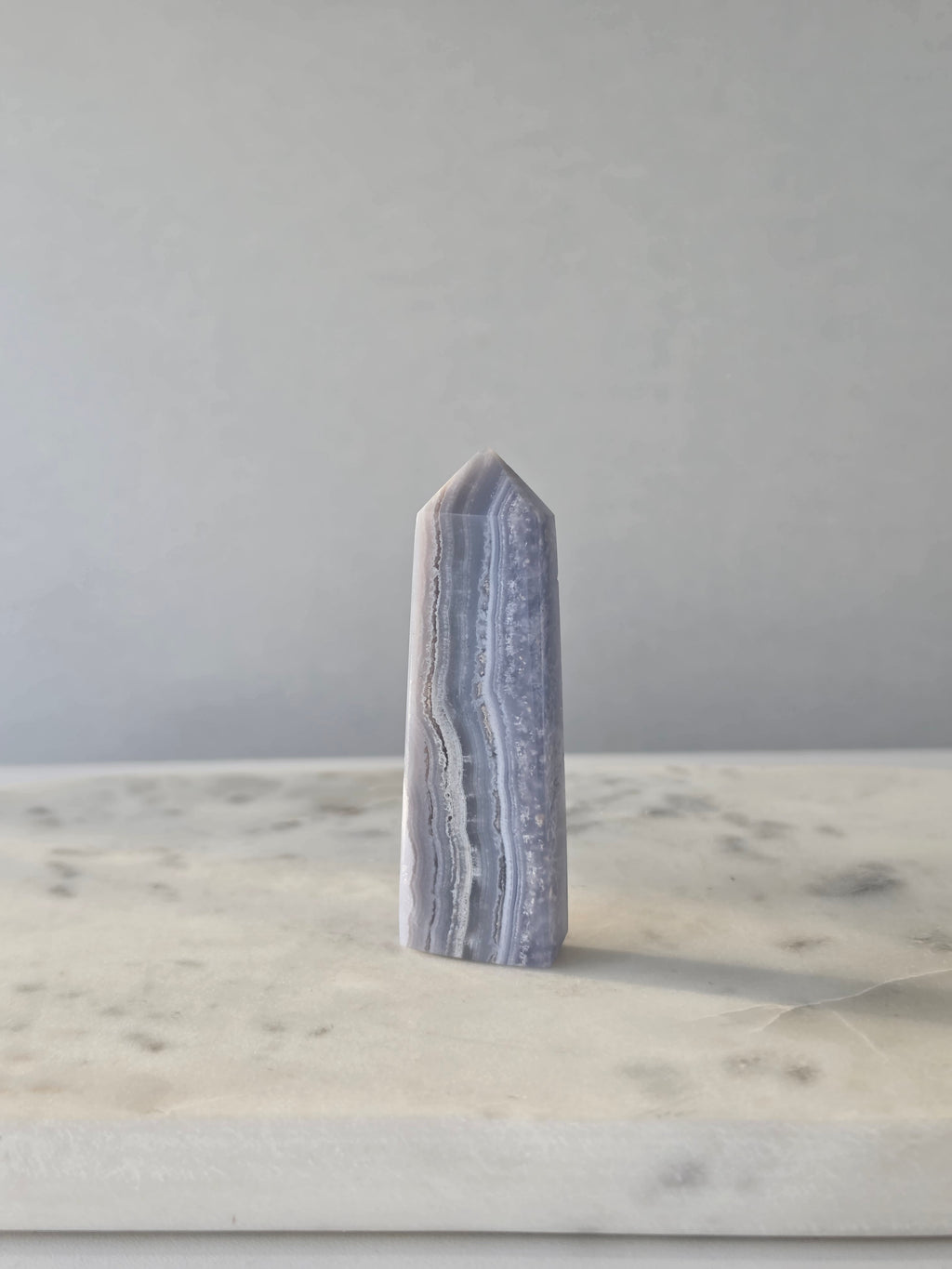 Natural Blue Lace Agate crystal point with soft blue and white banding, polished finish and unique natural formations