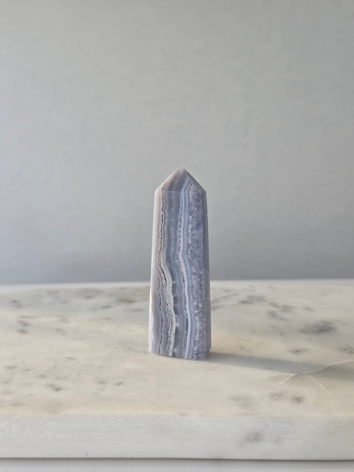 Natural Blue Lace Agate crystal point with soft blue and white banding, polished finish and unique natural formations