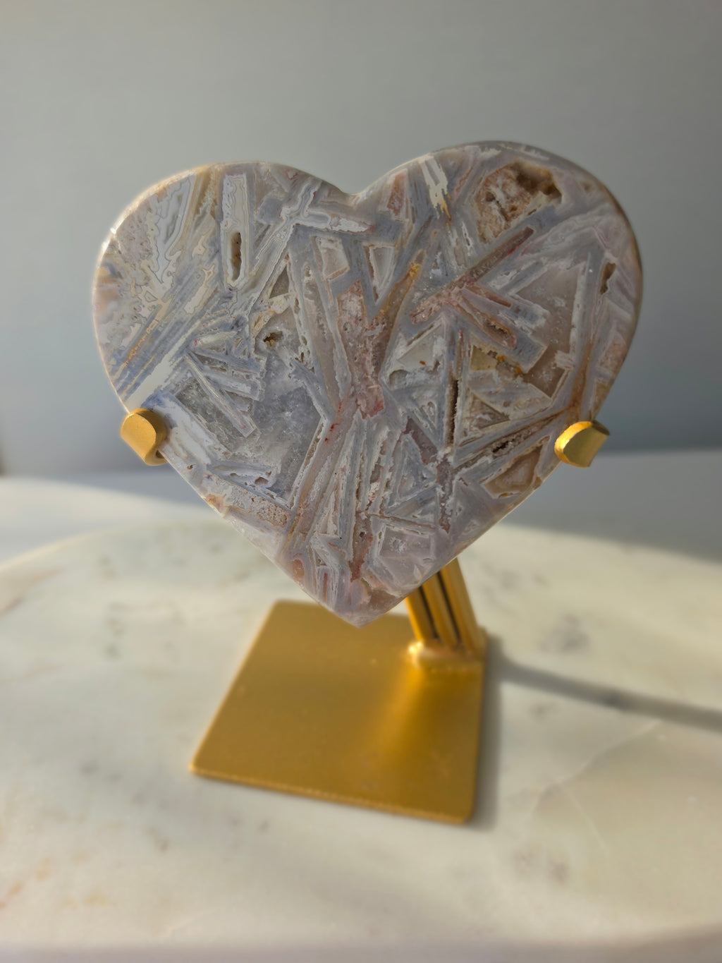 Brazilian Pink Amethyst heart on gold stand featuring intricate white palhetados splinter-like formations, soft blush pink colouring and natural mineral inclusions