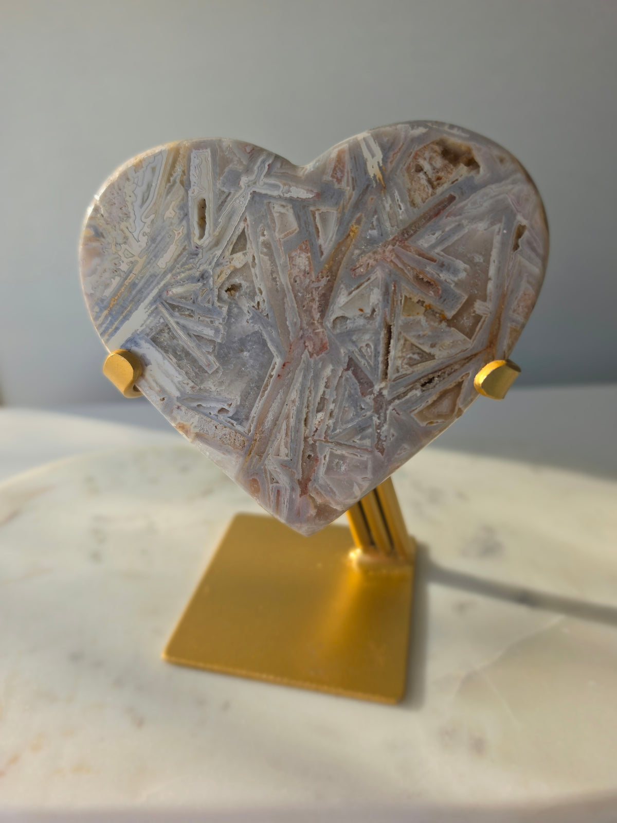 Brazilian Pink Amethyst heart on gold stand featuring intricate white palhetados splinter-like formations, soft blush pink colouring and natural mineral inclusions