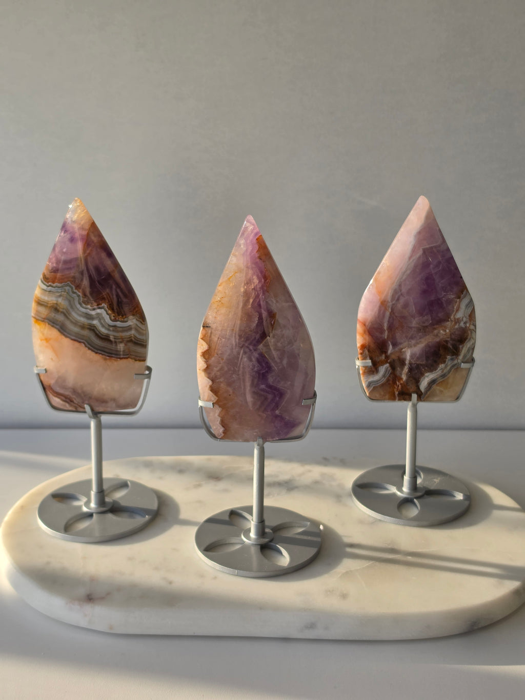 Amethyst Lace Agate flame on a silver stand featuring soft lavender, lilac and creamy white natural banding and intricate lace-like patterns, luxury crystal décor.