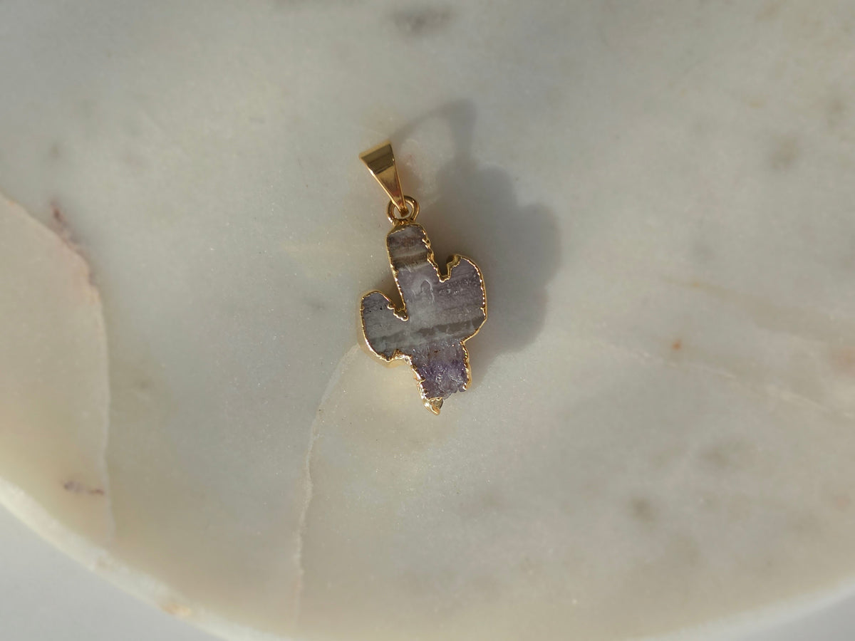 Amethyst and agate cactus slice pendant featuring agate banding, purple crystal formations and a 24K gold-plated outline.
