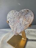 Brazilian Pink Amethyst heart on gold stand featuring intricate white palhetados splinter-like formations, soft blush pink colouring and natural mineral inclusions