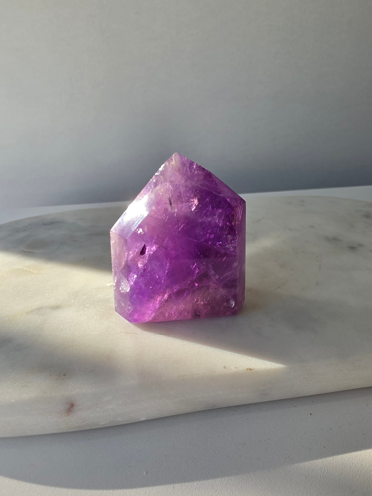 High clarity purple Amethyst tower from Brazil featuring rich violet and lavender hues, translucent crystal formations and polished reflective facets.