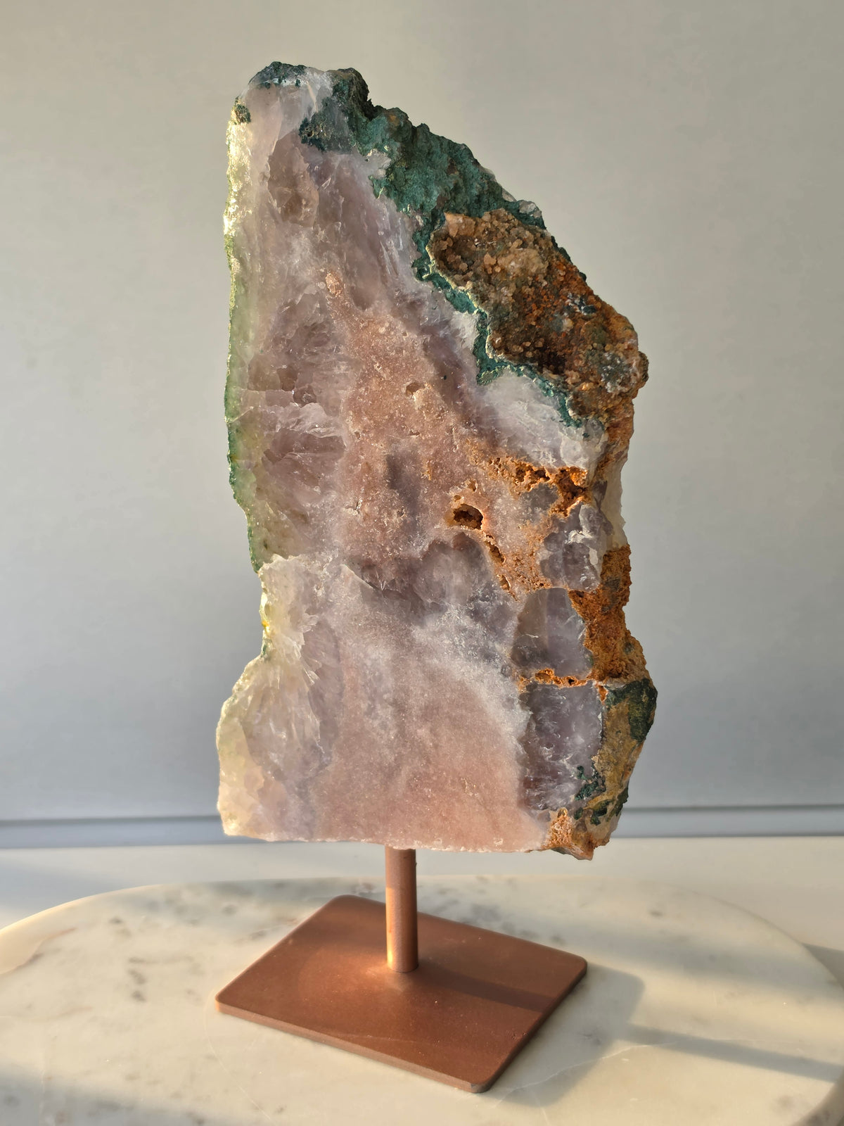 Large Brazilian Pink Amethyst slice on display stand with translucent Quartz, sparkling crystalline texture, earthy brown Jasper features and deep green natural matrix