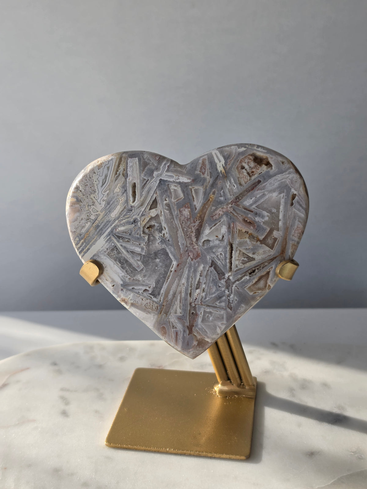 Brazilian Pink Amethyst heart on gold stand featuring intricate white palhetados splinter-like formations, soft blush pink colouring and natural mineral inclusions