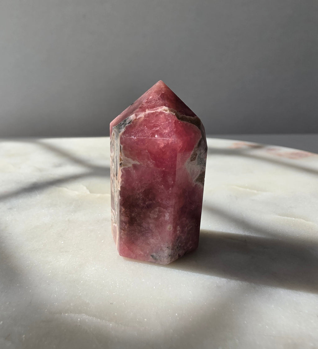 Polished Argentine Rhodochrosite crystal point with deep raspberry pink colour and intricate cream, blush and dark mineral banding, 37g, 4cm.