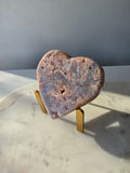 Pink Amethyst heart with soft pink and lilac colouring, intricate palhetados splinter-like formations, natural cavities and sparkling crystalline pockets on a gold stand