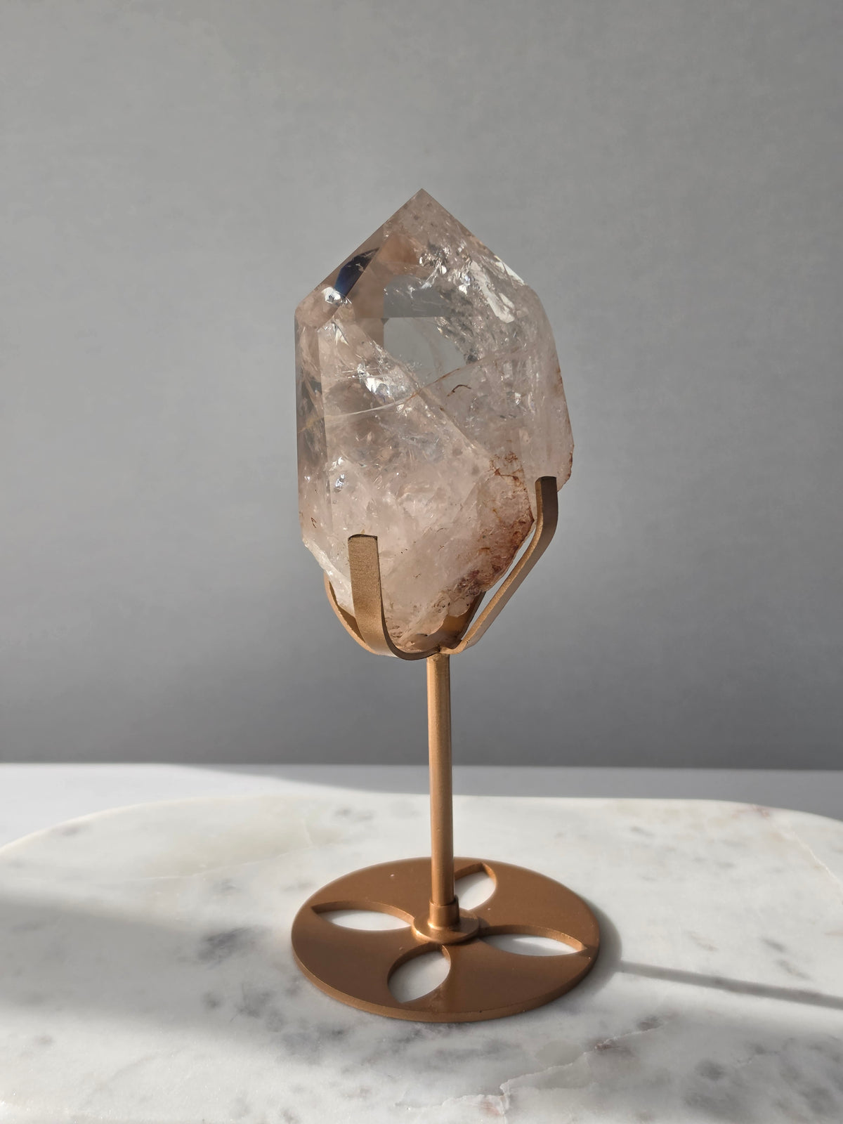 High-grade Nepalese Pink Himalayan Quartz statement piece, 606g and 19cm tall, featuring delicate pink tones, translucent crystal formations and natural inclusions, displayed on a gold stand.