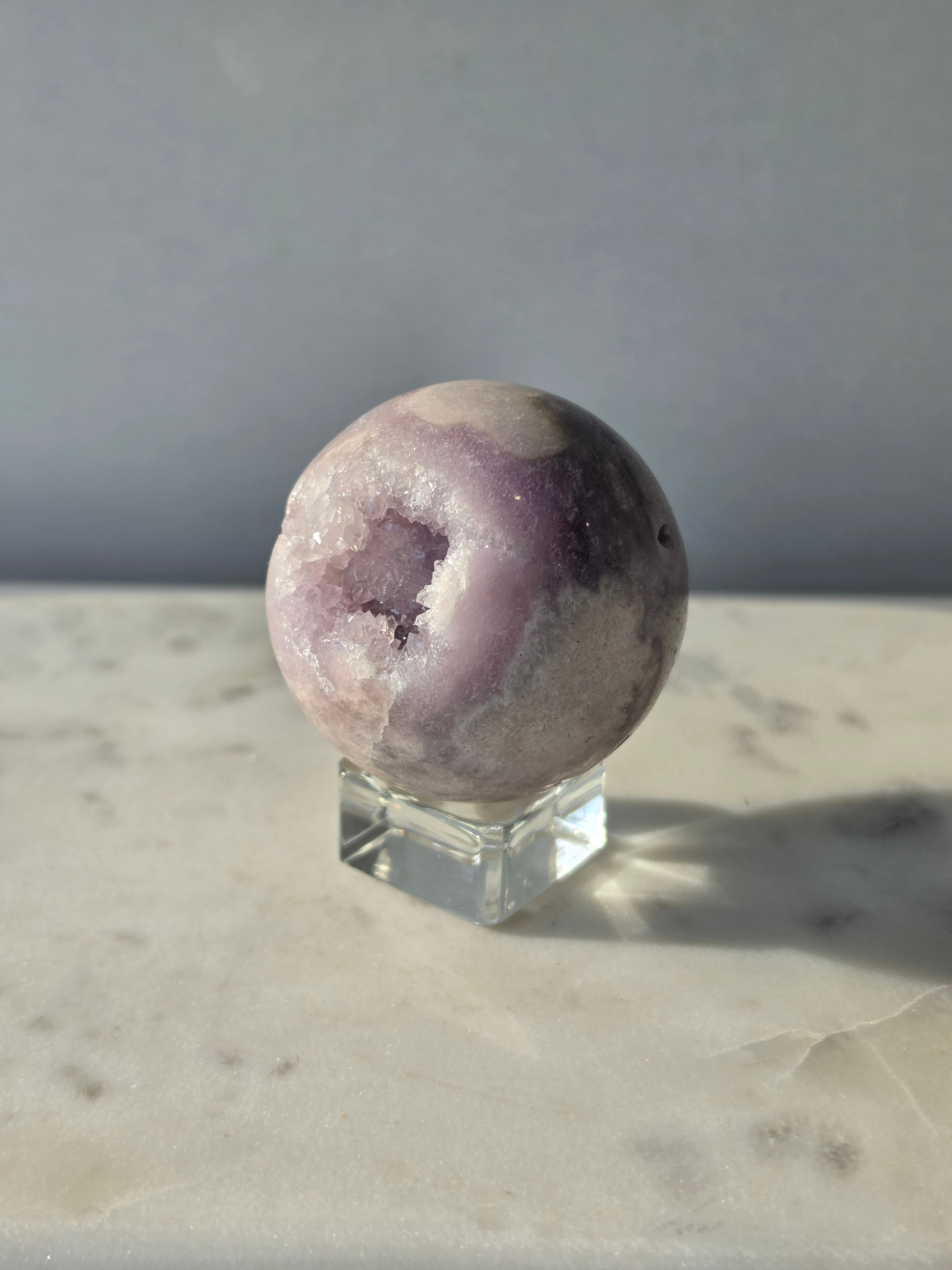 Brazilian Pink Amethyst sphere in soft lilac and lavender tones featuring a sparkling druzy cavity with a natural amethyst flower formation