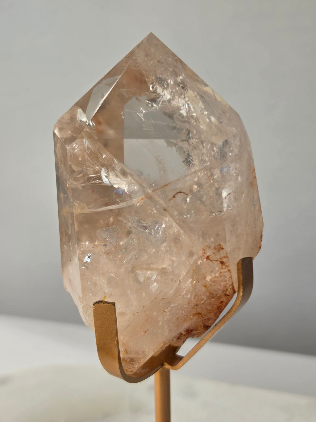 High-grade Nepalese Pink Himalayan Quartz statement piece, 606g and 19cm tall, featuring delicate pink tones, translucent crystal formations and natural inclusions, displayed on a gold stand.