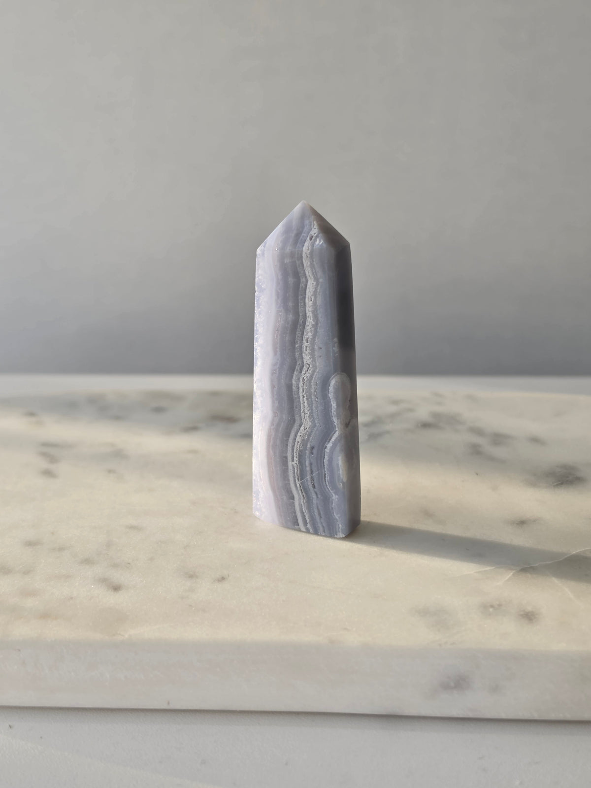 Natural Blue Lace Agate crystal point with soft blue and white banding, polished finish and unique natural formations