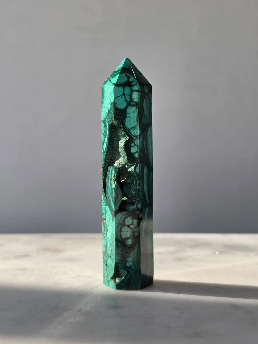 Polished green Malachite Point featuring deep emerald bands, concentric bubble-like formations with sparkles and intricate natural patterns.