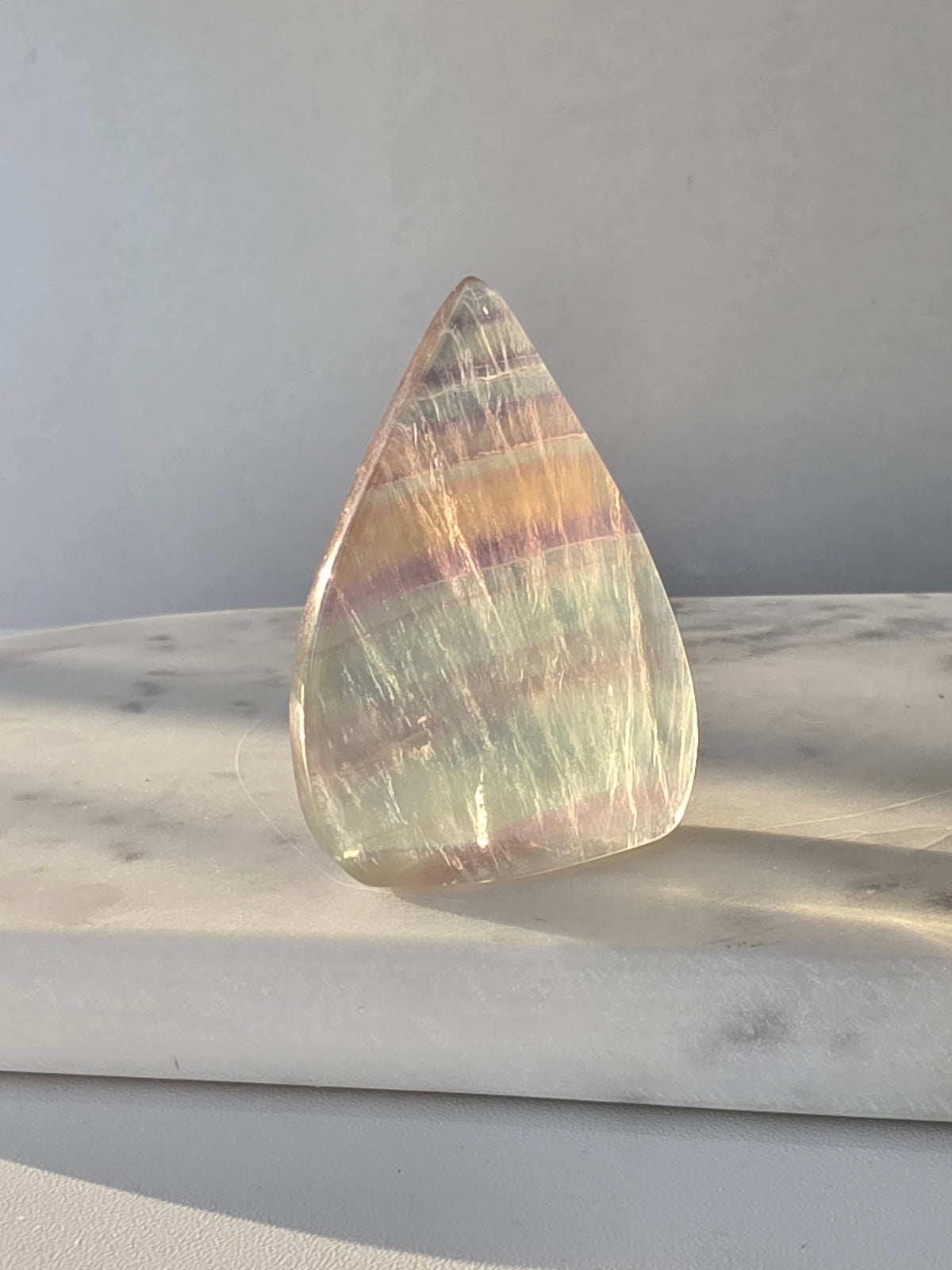 Natural Candy Fluorite crystal flame with pastel purple, blue and green tones, translucent colour zoning and polished finish