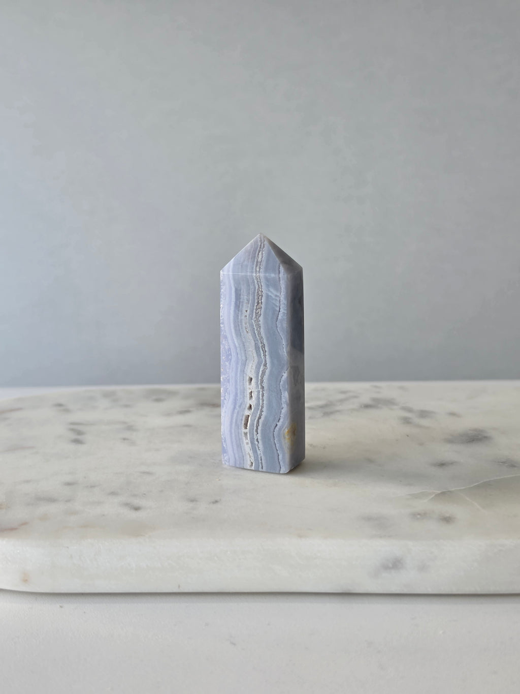 Natural Blue Lace Agate crystal point with soft blue and white banding, polished finish and unique natural formations