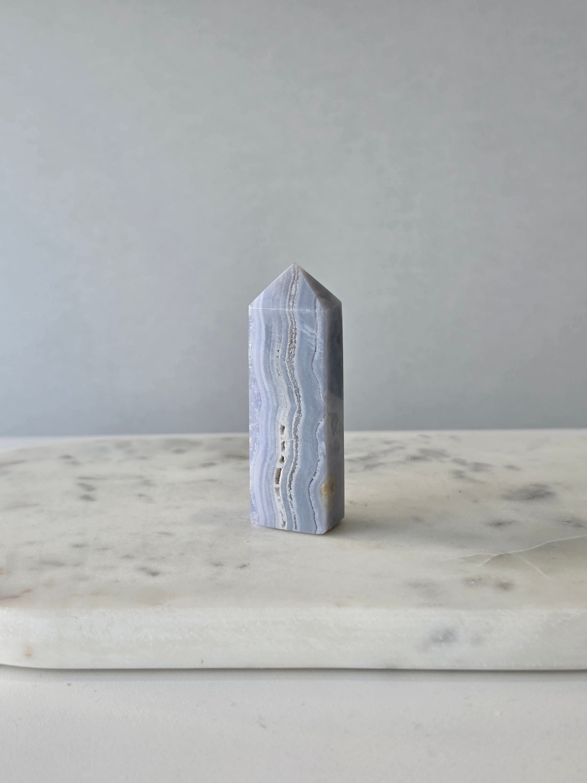 Natural Blue Lace Agate crystal point with soft blue and white banding, polished finish and unique natural formations