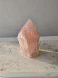 Natural Rose Quartz tower with soft blush-pink colouring and subtle warm golden healer inclusions, weighing 466g and measuring 10cm