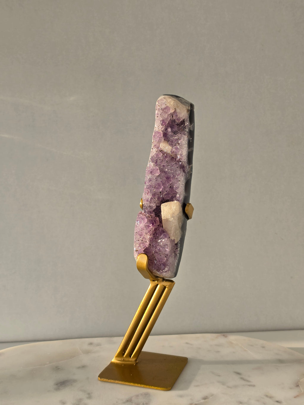 Brazilian Purple Amethyst Freeform with natural golden Calcite on gold stand, featuring sparkling druzy crystal points and polished finish – luxury crystal home décor by Stone & Bloom.