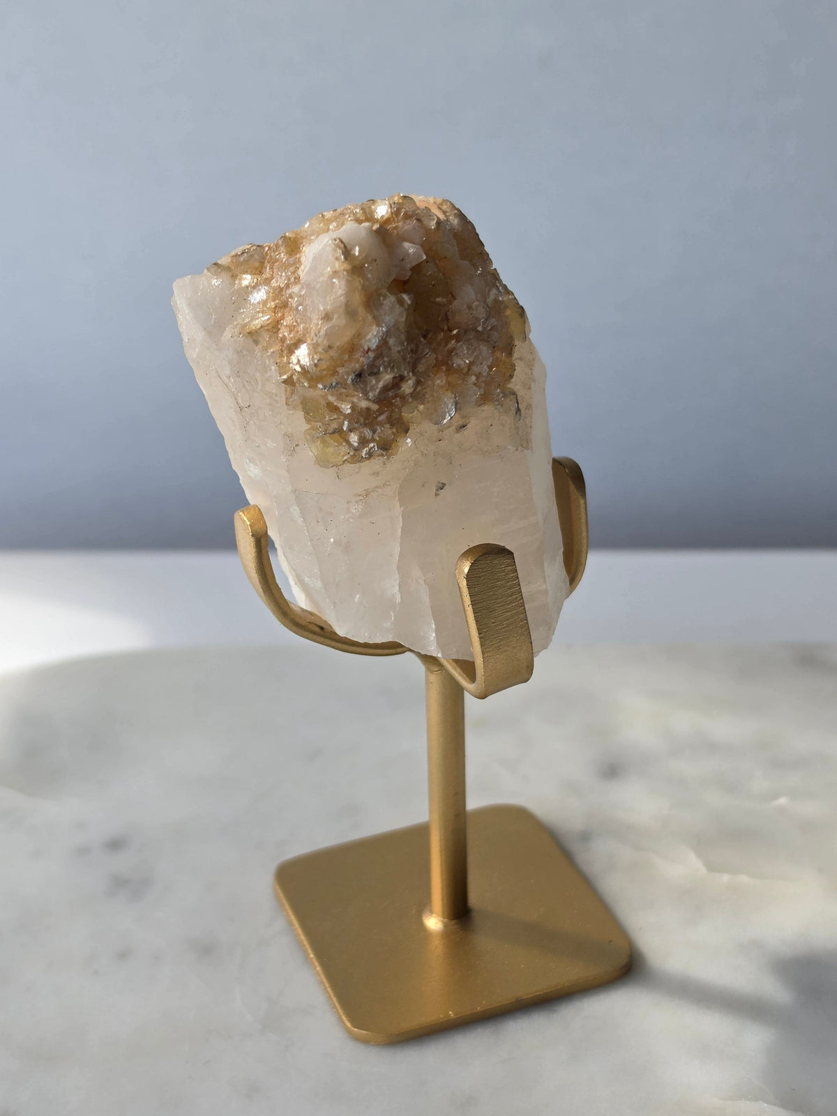 Brazilian Golden Mica on Matrix mineral specimen featuring shimmering golden mica crystals within a pale translucent matrix, displayed on a gold-toned stand.