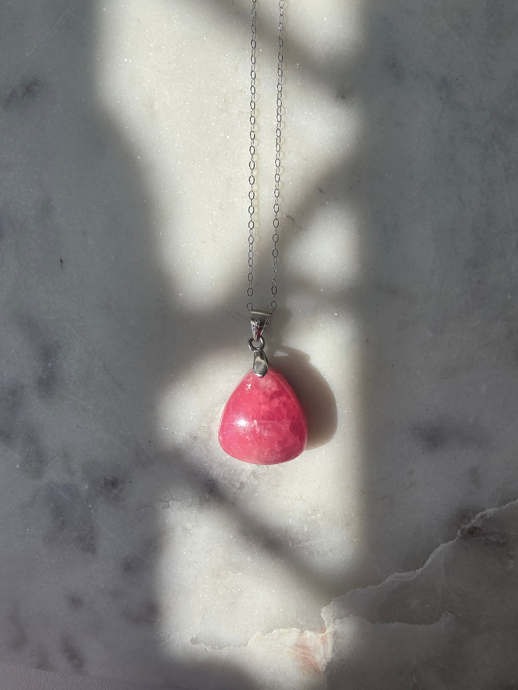 Natural Rhodochrosite teardrop pendant in 925 sterling silver with matching silver chain, featuring vibrant pink tones and unique natural patterns
