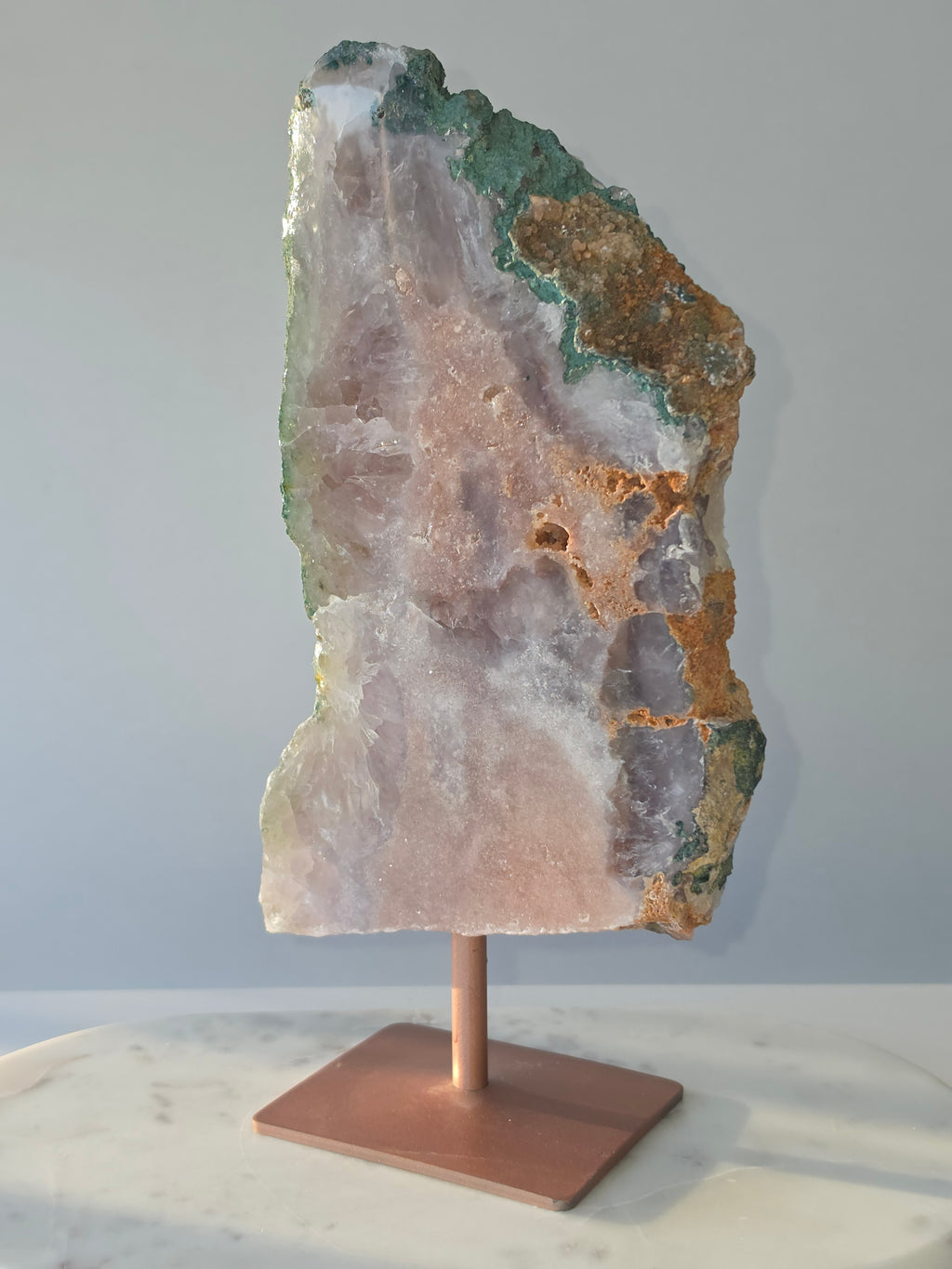 Large Brazilian Pink Amethyst slice on display stand with translucent Quartz, sparkling crystalline texture, earthy brown Jasper features and deep green natural matrix