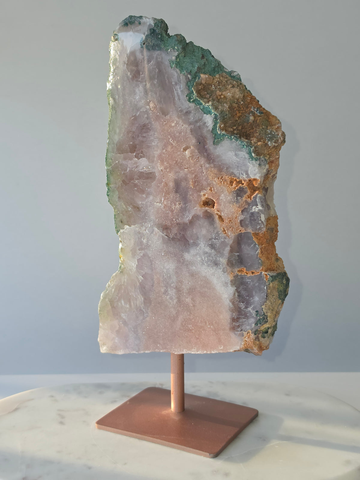 Large Brazilian Pink Amethyst slice on display stand with translucent Quartz, sparkling crystalline texture, earthy brown Jasper features and deep green natural matrix