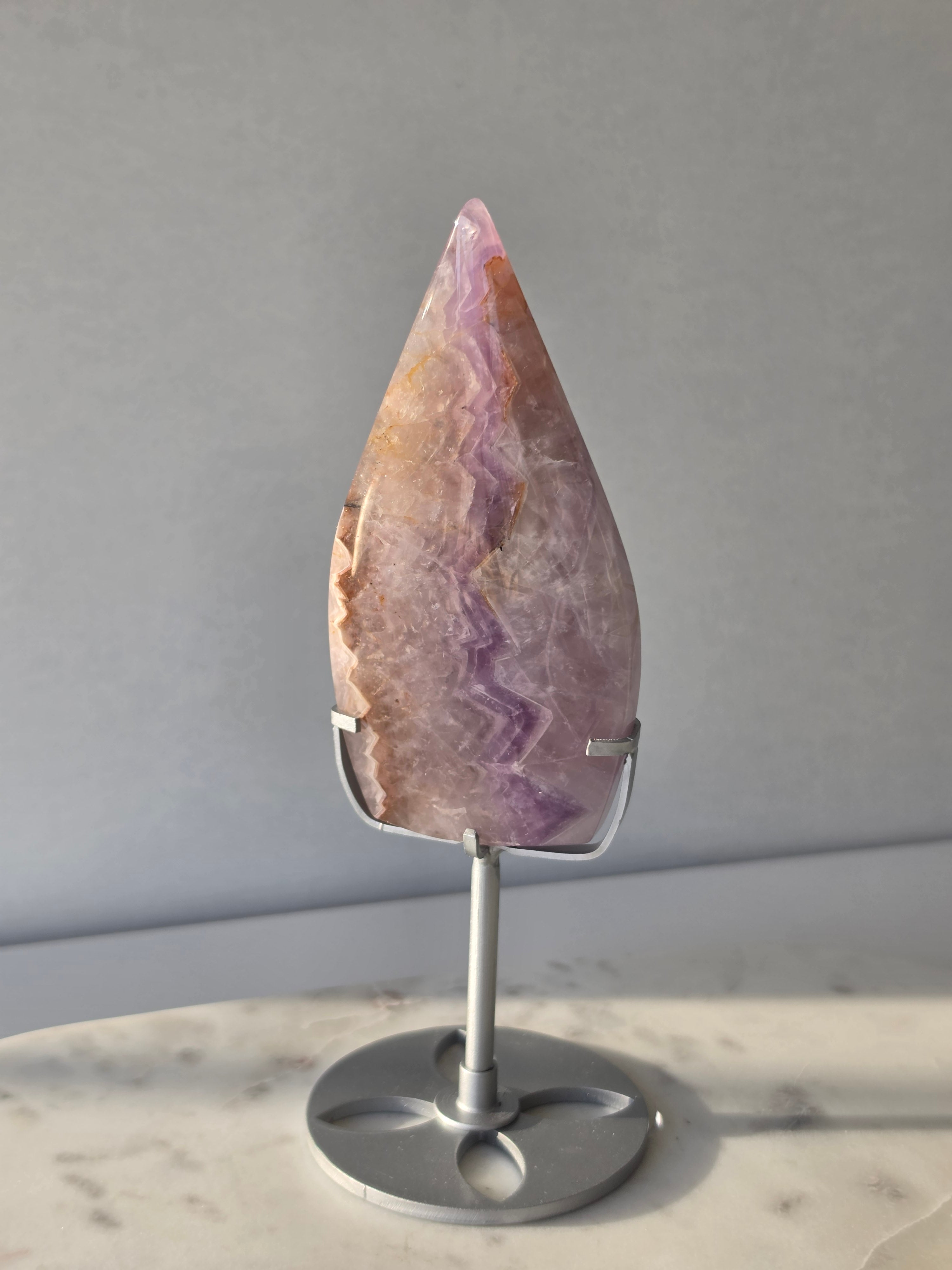 Amethyst Lace Agate flame on a silver stand featuring soft lavender, lilac and creamy white natural banding and intricate lace-like patterns, luxury crystal décor.