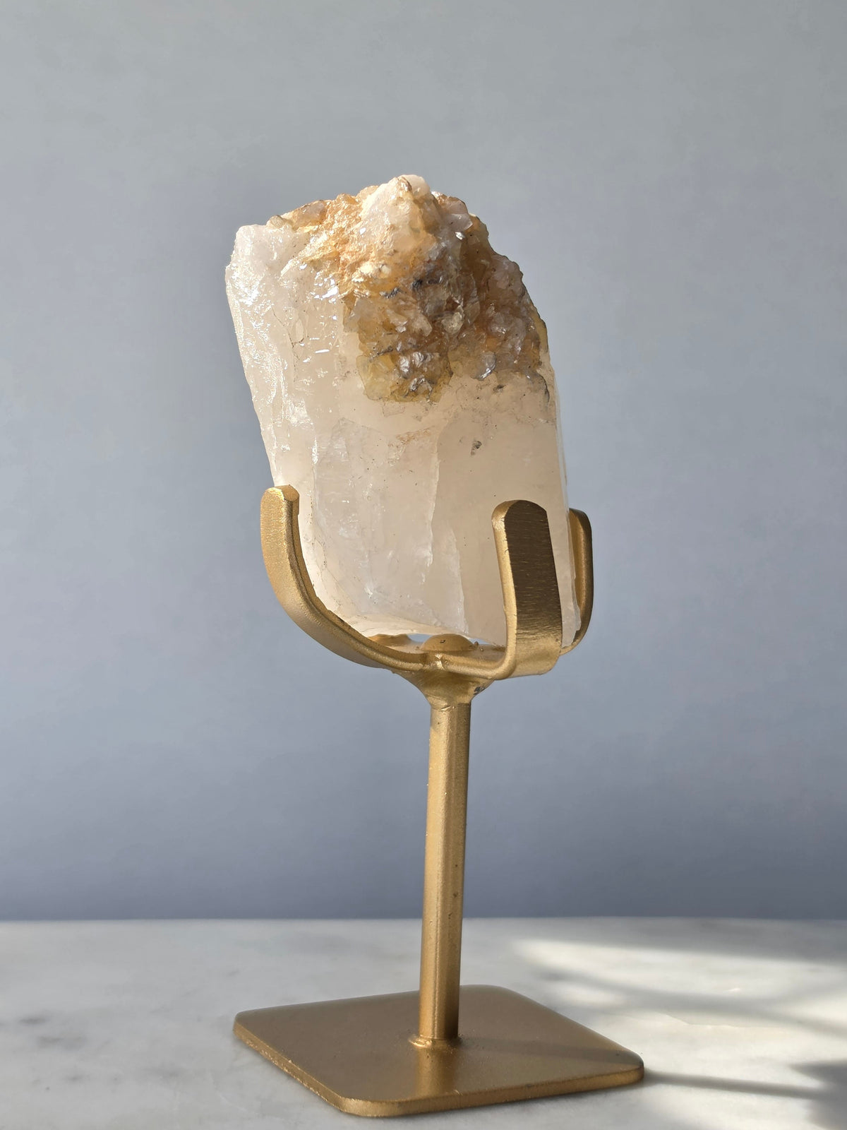 Brazilian Golden Mica on Matrix mineral specimen featuring shimmering golden mica crystals within a pale translucent matrix, displayed on a gold-toned stand.